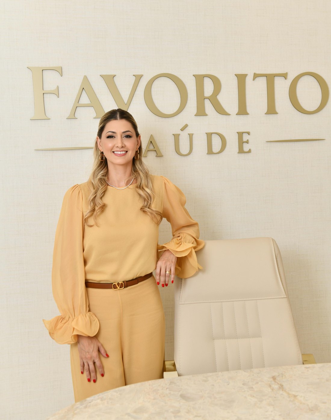 Dra. Flávia Soares Favorito, Diretora Executiva da Favorito Saúde, ao lado do letreiro da clínica