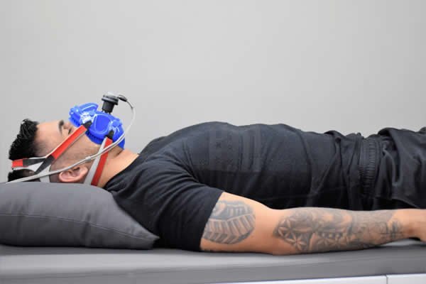 Paciente deitado com máscara de análise respiratória durante exame de calorimetria